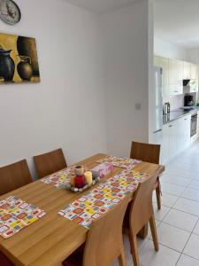 een keuken met een houten tafel met stoelen eromheen bij Iris Village Grand Apartment in Paphos City