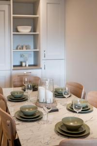una mesa de comedor con platos y copas de vino en No.3 Mill Park a luxury self-catering apartment en Donegal