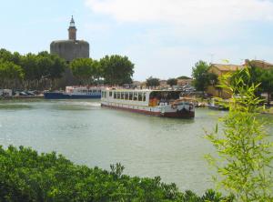 un barco está atracado en un río cerca de una ciudad en Bateau Le Phénicien, en Aigues-Mortes