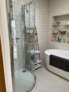 a bathroom with a shower and a bath tub at Teal Cottage, Killlyleagh in Killyleagh