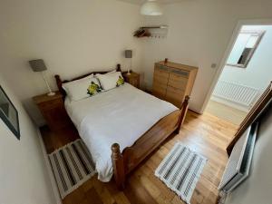 a bedroom with a bed and a wooden floor at Teal Cottage, Killlyleagh in Killyleagh