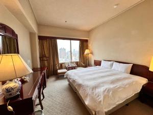 a hotel room with a bed and a large window at T Hotel in Taichung