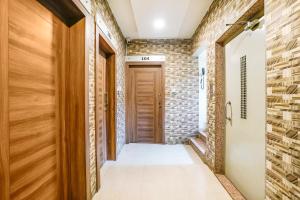 a hallway with a wooden door and a brick wall at FabHotel Candor Amigo in Navi Mumbai