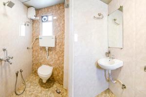 a bathroom with a toilet and a sink at FabHotel Candor Amigo in Navi Mumbai