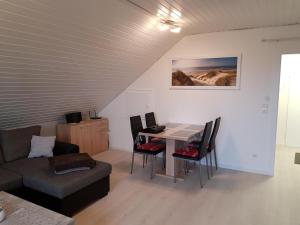 a living room with a table and chairs and a couch at Ferienwohnung Schäfer Deichgraf in Burhave
