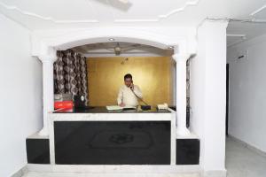 um homem atrás de um balcão numa sala em OYO Flagship Hotel Novelty Pride em Bankipur