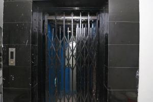 a blue door in a black tiled wall at OYO Flagship Hotel Novelty Pride in Bankipur