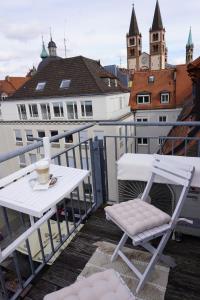 einen Tisch und einen Stuhl auf einem Balkon mit einer Tasse Kaffee in der Unterkunft City Apartement im Herzen der Stadt in Würzburg