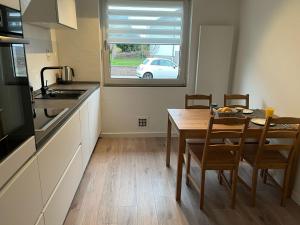a kitchen with a dining room table and a window at Ferienwohnung Wendel in Sankt Wendel +4 photos