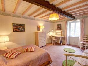ein Schlafzimmer mit einem Bett und einem Schreibtisch in einem Zimmer in der Unterkunft Gîte Saint-Alban-les-Eaux, 7 pièces, 10 personnes - FR-1-496-95 in Saint-Alban-les-Eaux