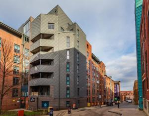 ein Gebäude mit pyramidenförmiger Fassade auf einer Stadtstraße in der Unterkunft Modern Stylish Apartments and Rooms at Student Roost Corner House in Sheffield in Sheffield