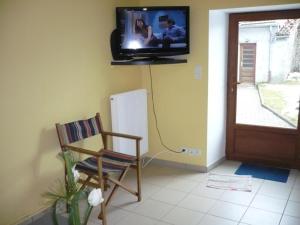 a room with a chair and a tv on the wall at Gîte La Chambonie, 4 pièces, 5 personnes - FR-1-496-199 in La Chambonie