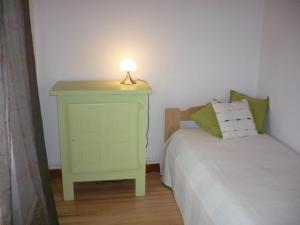 un comodino verde con una lampada accanto al letto di Charmant gîte 3 chambres avec jardin, proche activités neige et randonnées, animaux acceptés ! - FR-1-496-199 a La Chambonie