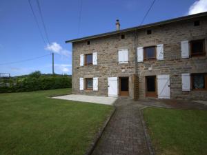 a brick building with white doors and a grass yard at Gîte La Chambonie, 4 pièces, 5 personnes - FR-1-496-199 in La Chambonie