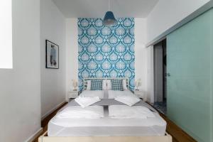 Schlafzimmer mit einem Bett mit blauer Wand in der Unterkunft HM • Chic Studio Near Metro & Center in Wien