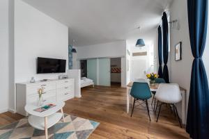 ein weißes Wohnzimmer mit einem Tisch und Stühlen in der Unterkunft HM • Chic Studio Near Metro & Center in Wien