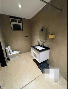 a bathroom with a toilet and a sink and a mirror at Redhomex Cove Castle Villa in Hyderabad