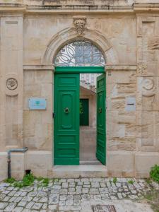einen Eingang zu einem Gebäude mit grüner Tür in der Unterkunft Scicli Albergo Diffuso in Scicli
