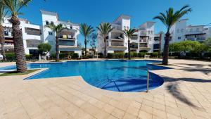 una piscina con palmeras y edificios en Casa Fresa, A Simply Spanish Rentals Property, en Murcia