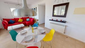 sala de estar con mesa, sillas y sofá rojo en Casa Fresa, A Simply Spanish Rentals Property, en Murcia