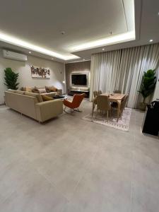 a living room with a couch and a table at شقة انيقة بثلاث غرف نوم in Riyadh