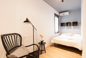 1 dormitorio con 1 cama, 1 silla y 1 lámpara en AB Sagrada Família Comfort, en Barcelona