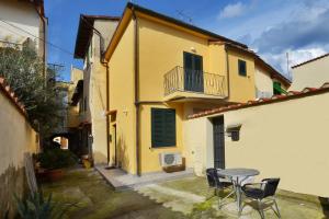 una casa gialla con tavolo e sedie in cortile di Casina Valentina - Happy Rentals a Firenze