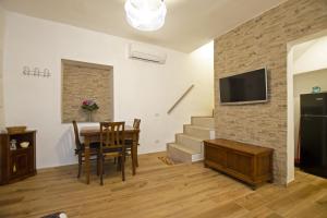 a living room with a dining room table and a television at Casina Valentina - Happy Rentals in Florence