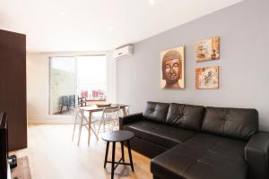 sala de estar con sofá negro y mesa en AB Sagrada Família Comfort, en Barcelona