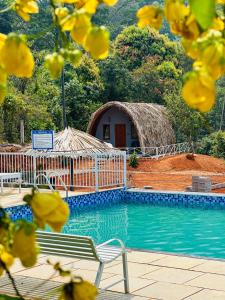 a swimming pool with a gazebo and a house at Historic Heaven wayanad in Vythiri
