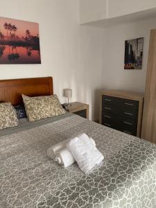 1 dormitorio con 1 cama con 2 toallas en apartamento turístico CUATRO CAMINOS, en San Vicente de Alcántara