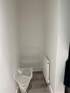 a white room with a radiator and a chair at Entire One Bedroom Rental Unit in Kent in Kent
