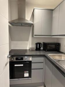 een keuken met witte kasten en een fornuis met oven bij Entire One Bedroom Rental Unit in Kent in Kent