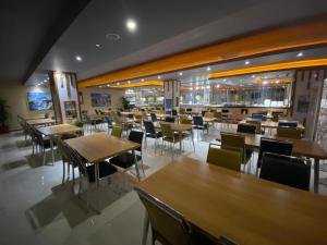een restaurant met houten tafels en stoelen en een cafetaria bij ADA LİFE SUİT HOTEL VAN in Bostaniçi