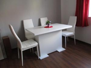 un tavolo bianco con sedie bianche e un tavolo e sedie bianchi di Ferienwohnung Thüringer Wald a Ilmenau