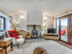 a living room with a fireplace and a tv at The Shippon in Halwill