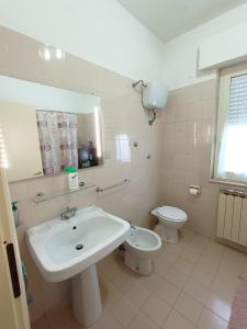 La salle de bains blanche est pourvue d'un lavabo et de toilettes. dans l'établissement Domus Stadio, à Pescara
