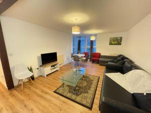 a living room with a black couch and a tv at Spacious 2BD apartment in Central London in London