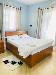 una camera da letto con un grande letto con lenzuola bianche di Venem Ensuite bathroom Elephant house a Kisongo