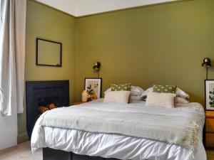 a bedroom with a large bed with green walls at Main Street Flat B - Uk46449 in Ayr
