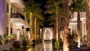 a lobby with palm trees and a building with lights at النخيل رست in Al Shafa