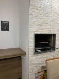 a brick fireplace in a living room with a table at Apartamento acqua in Pelotas