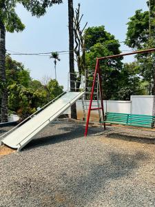 a slide and a bench in a park at Brooke Forest Heaven Resort in Vythiri