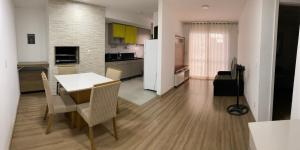 a kitchen and living room with a table and chairs at Apartamento acqua in Pelotas