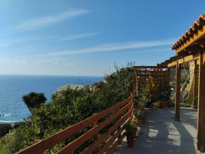 a wooden fence and a walkway next to the ocean at Virgin Beauty in Armenistis