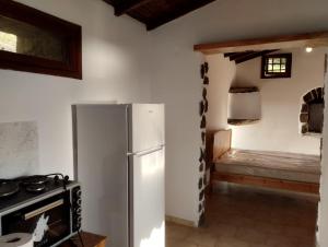 a kitchen with a refrigerator and a room with a bed at Virgin Beauty in Armenistis