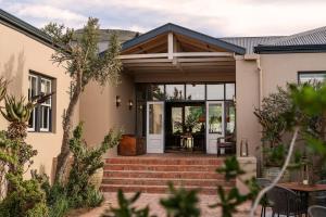 Ein Haus mit einer Eingangstür und einer Terrasse in der Unterkunft Samara Karoo Reserve in Graaff-Reinet