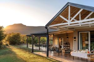 an outdoor dining area with tables and chairs at Samara Karoo Reserve in Graaff-Reinet