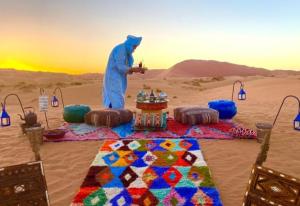 a man in the desert with a table in the sand at Galaxy stars camp in Hassilabied