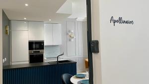 a kitchen with white cabinets and a black counter top at Appartement Apollinaire au cœur de Lorient in Lorient